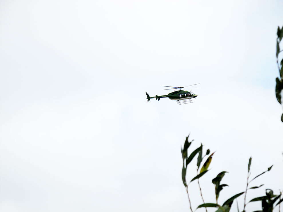 A Performer is flying in a Helicopter Bell 407 and looking at the exhibition from above for 2-3 minutes and then flying away.