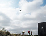A Performer is flying in a Helicopter Bell 407 and looking at the exhibition from above for 2-3 minutes and then flying away.