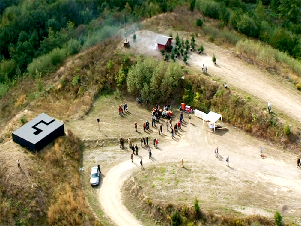 A Performer is flying in a Helicopter Bell 407 and looking at the exhibition from above for 2-3 minutes and then flying away.
