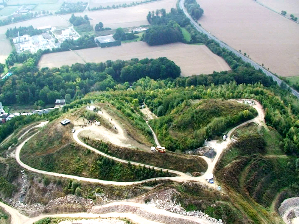 A Performer is flying in a Helicopter Bell 407 and looking at the exhibition from above for 2-3 minutes and then flying away.